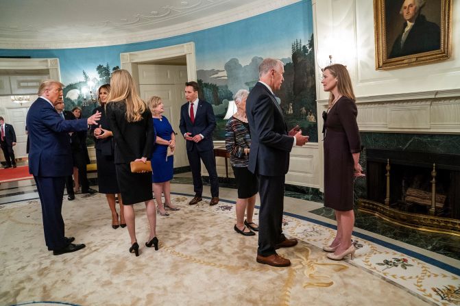 US Sen. Thom Tillis, who also later tested positive for coronavirus, talks to Barrett during <a href="https://www.cnn.com/2020/10/04/politics/gallery/barrett-announcement-inside-white-house-0926/index.html" target="_blank">the White House reception</a> on September 26. At left, President Trump and first lady Melania Trump talk with US Sen. Kelly Loeffler.