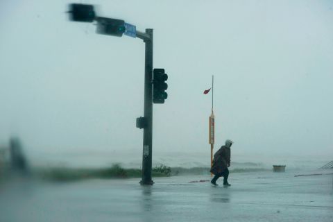 A man walks across the street as the outer bands of Hurricane Delta lash Galveston, Texas, on October 9.