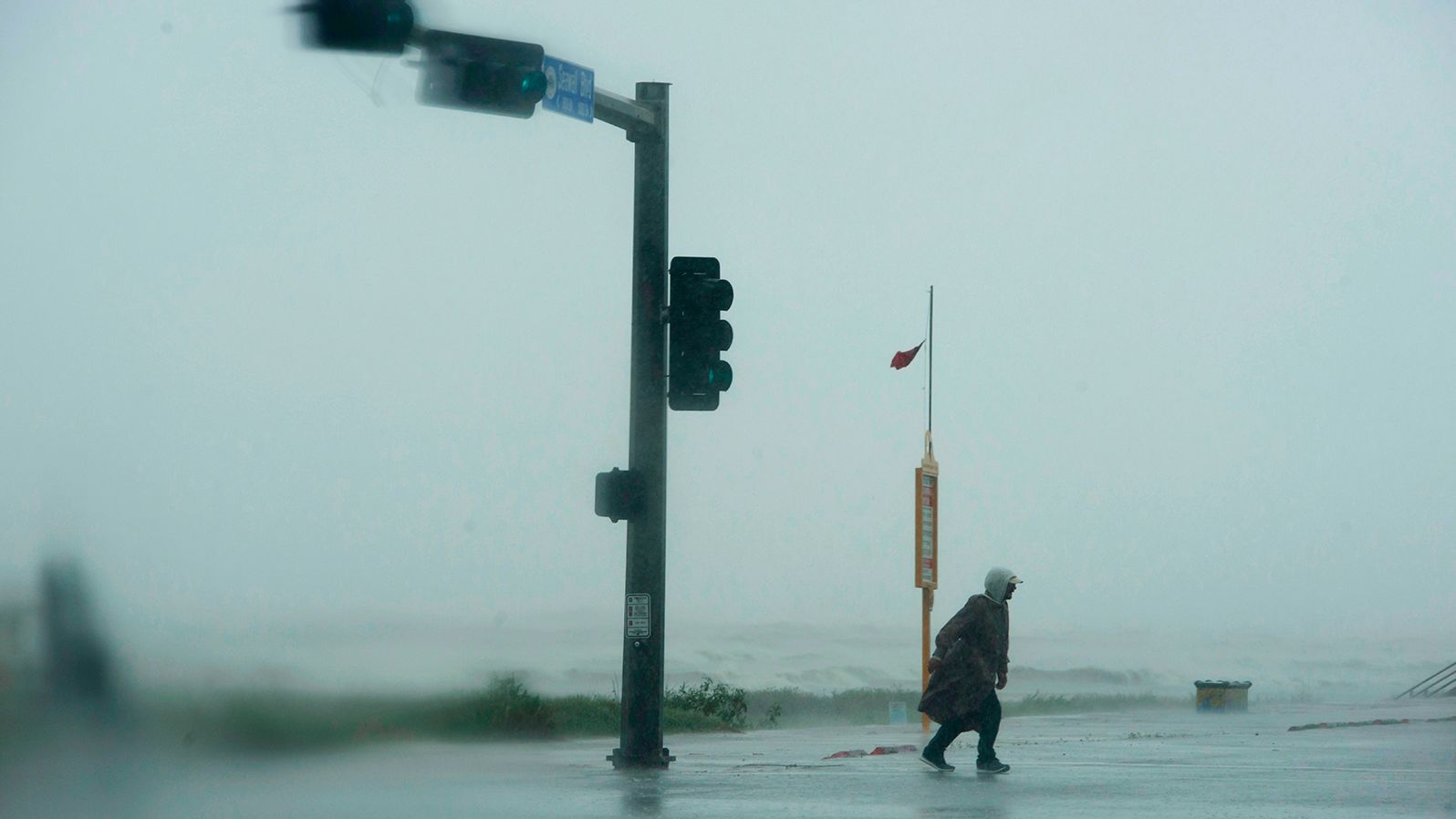 A man walks across the street as the outer bands of Hurricane Delta lash Galveston, Texas, on October 9.