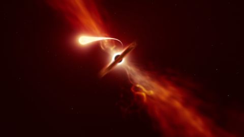 This illustration depicts a star (in the foreground) experiencing spaghettification as it's sucked in by a supermassive black hole (in the background) during a "tidal disruption event." 