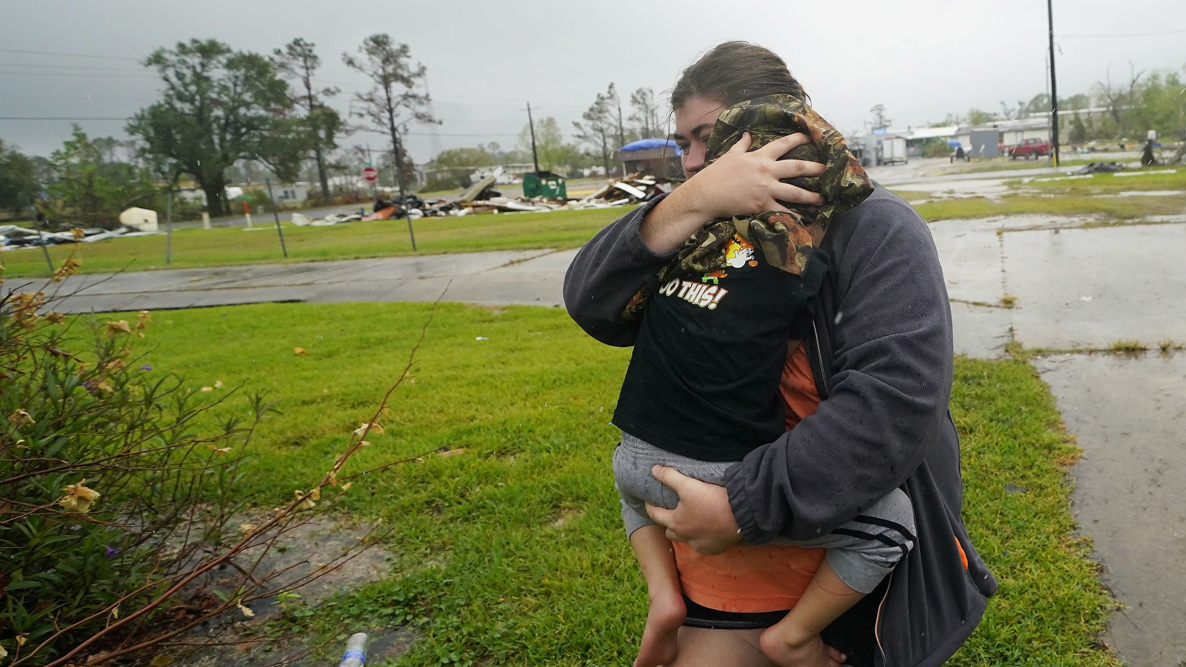 Danielle Fontenot runs to a relative's home in the rain with her son Hunter ahead of Hurricane Delta in Lake Charles, Louisiana, on October 9.