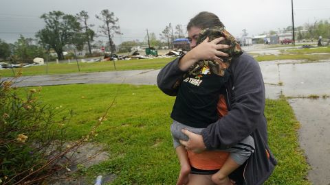 Danielle Fontenot runs to a relative's home in the rain with her son Hunter ahead of Hurricane Delta, Friday, Oct. 9, 2020, in Lake Charles, Louisiana.