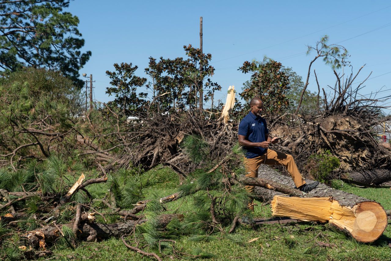 A reporter stands by trees felled by the storm in Jennings, Louisiana, on October 10.