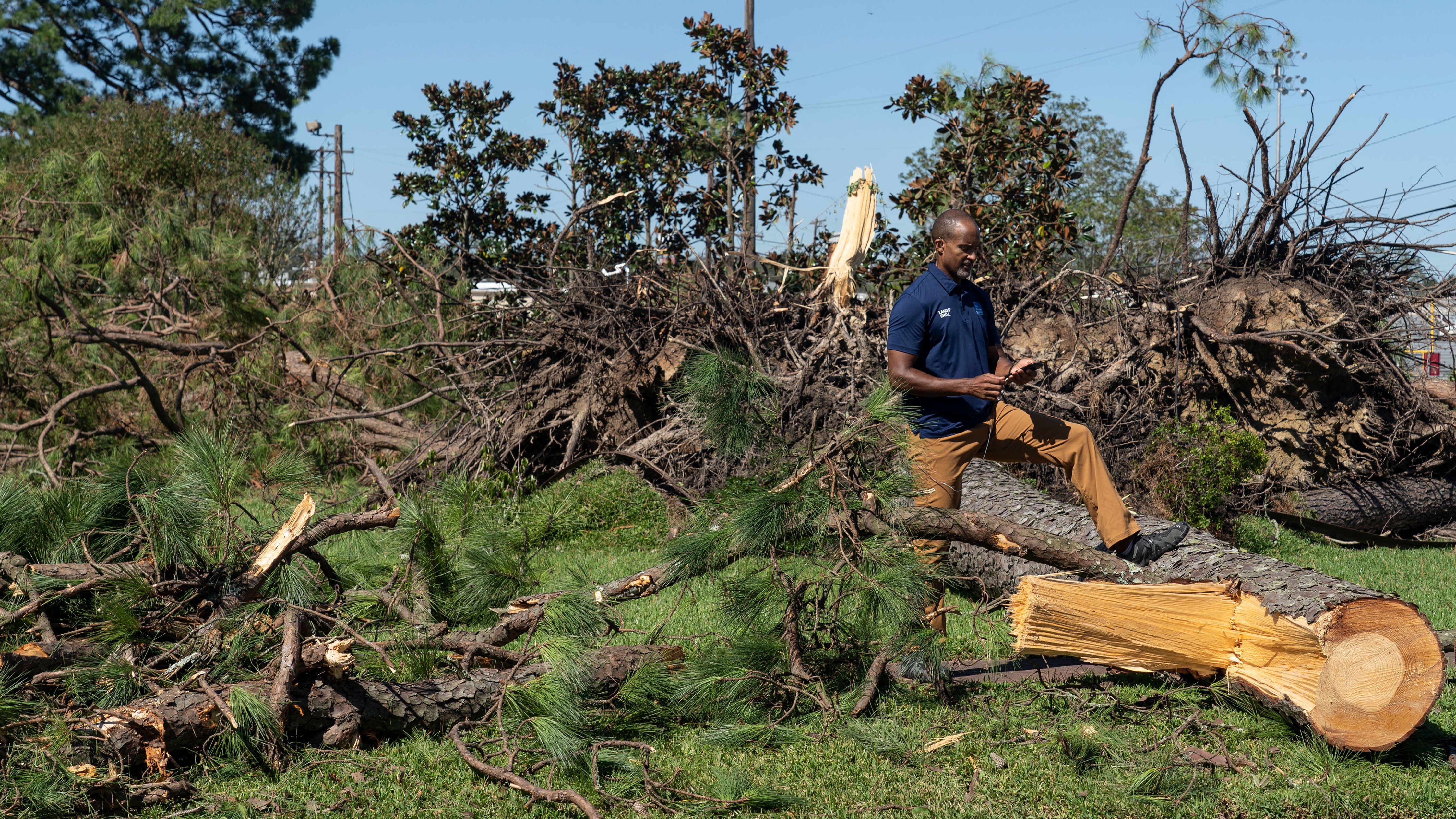 A reporter stands by trees felled by the storm in Jennings, Louisiana, on October 10.