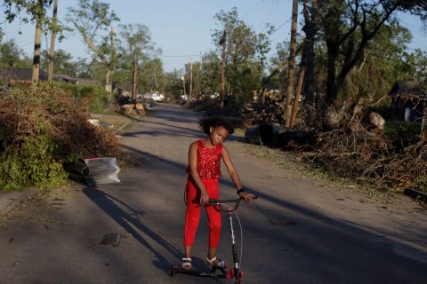 Iyana Sells, 9, plays on her street, which is still lined with debris from Hurricane Laura, the day after Hurricane Delta swept through Lake Charles, Louisiana, October 10. 