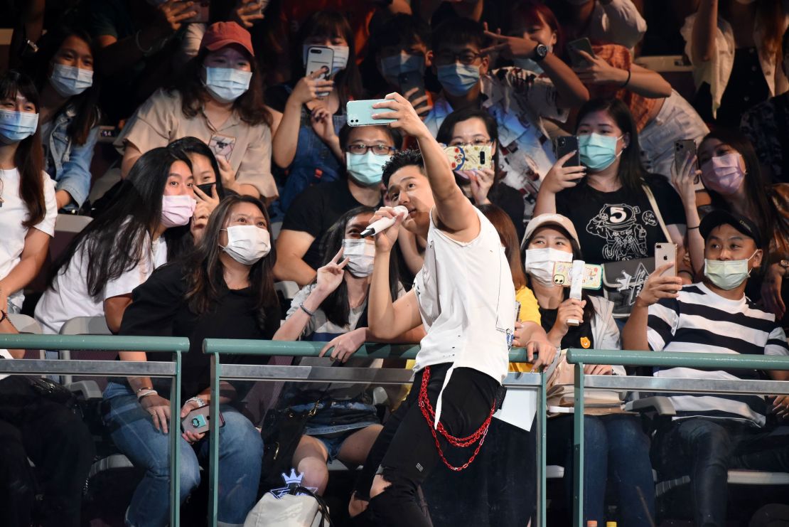 Singer Eric Chou takes a selfie with masked members of the audience while performing in a concert in Taipei, Taiwan, on August 9, 2020.