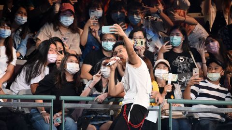 Singer Eric Chou takes a selfie with masked members of the audience while performing in a concert in Taipei, Taiwan, on August 9, 2020.