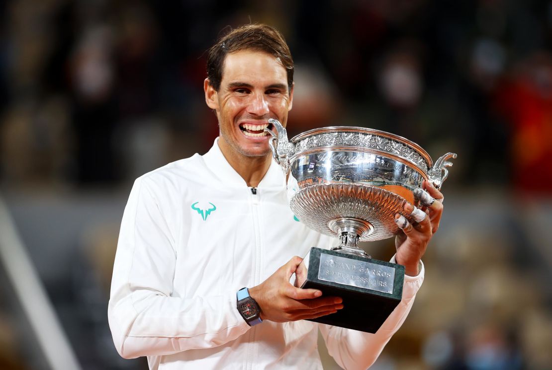 Rafael Nadal bites the winning trophy after claiming the French Open title for the 13th time  time with a straight sets victory over Novak Djokovic.