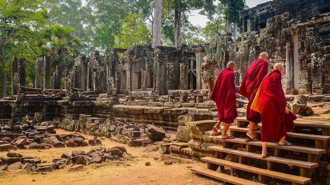 Buddhist monks enter the Bayon Temple at Angkor Wat in Cambodia.