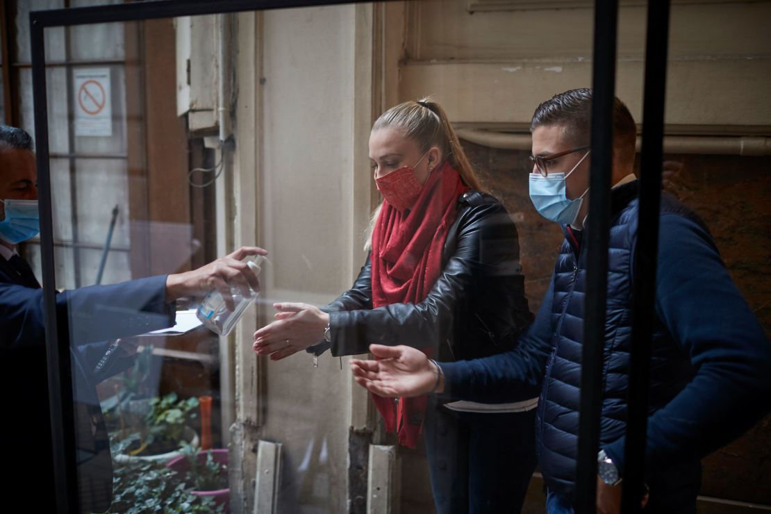 Customers receive hand sanitizer at the Chartier Bouillon Restaurant in Paris on Saturday. 