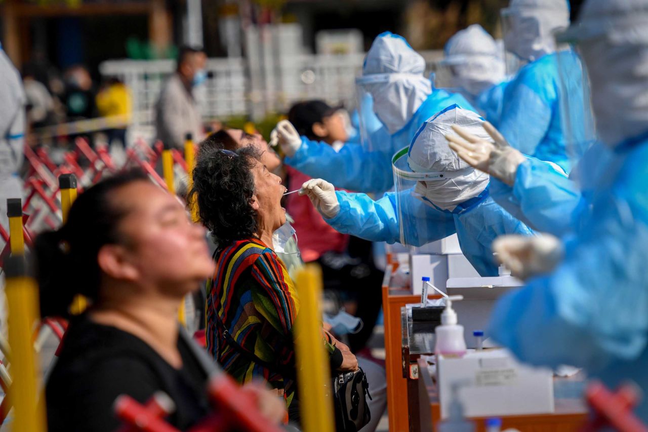 A health worker takes a swab from a resident at a Covid-19 testing center in Qingdao, China, on October 12. The Chinese port city planned to <a href="index.php?page=&url=https%3A%2F%2Fedition.cnn.com%2F2020%2F10%2F12%2Fasia%2Fchina-qingdao-coronavirus-golden-week-intl-hnk%2Findex.html" target="_blank">test some 9 million people</a> in the following days after 12 locally transmitted cases were reported.