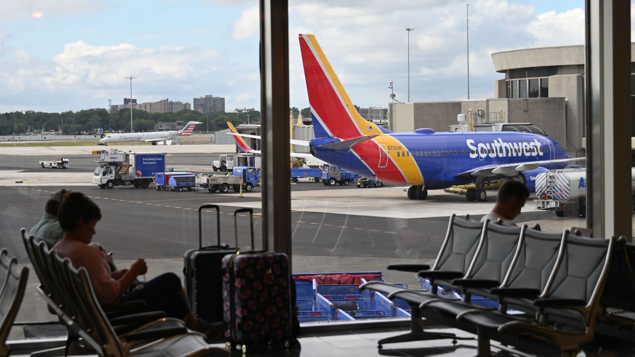 Passengers wait at the Southwest Airlines counter at Ronald Reagan Washington National Airport on July 10, 2020, in Arlington, Virginia, during the coronavirus pandemic. (Photo by Daniel SLIM / AFP) (Photo by DANIEL SLIM/AFP via Getty Images)
