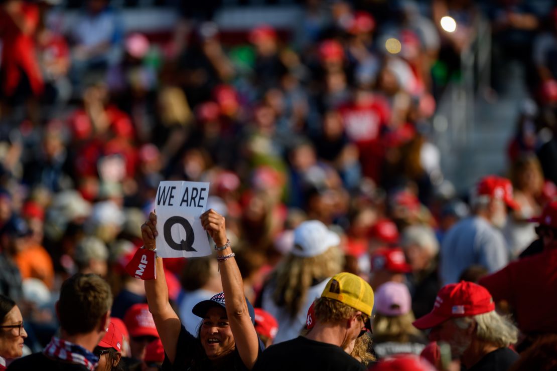 A woman holds up a QAnon sign to the media as attendees wait for President Donald Trump to speak at a campaign rally at Atlantic Aviation on September 22 in Moon Township, Pennsylvania.