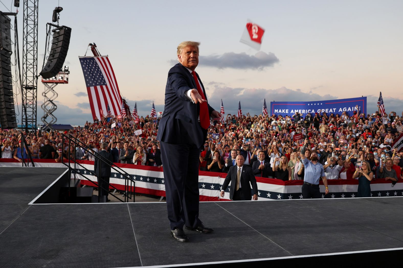 Trump tosses face masks to the crowd as he takes the stage for a campaign rally in Sanford, Florida, on October 12.