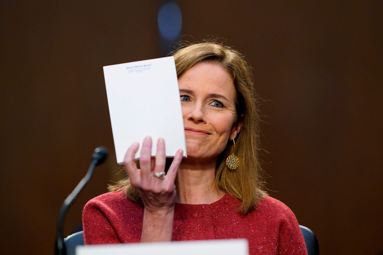 Barrett holds up a blank piece of paper after US Sen. John Cornyn, a Republican from Texas, asked her what notes she was using during her testimony. 