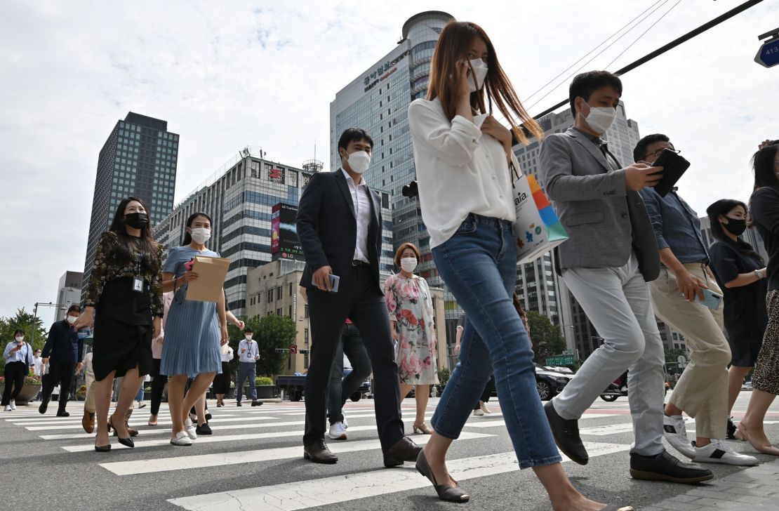 People wearing face masks cross a road in Seoul on September 11, 2020. 
