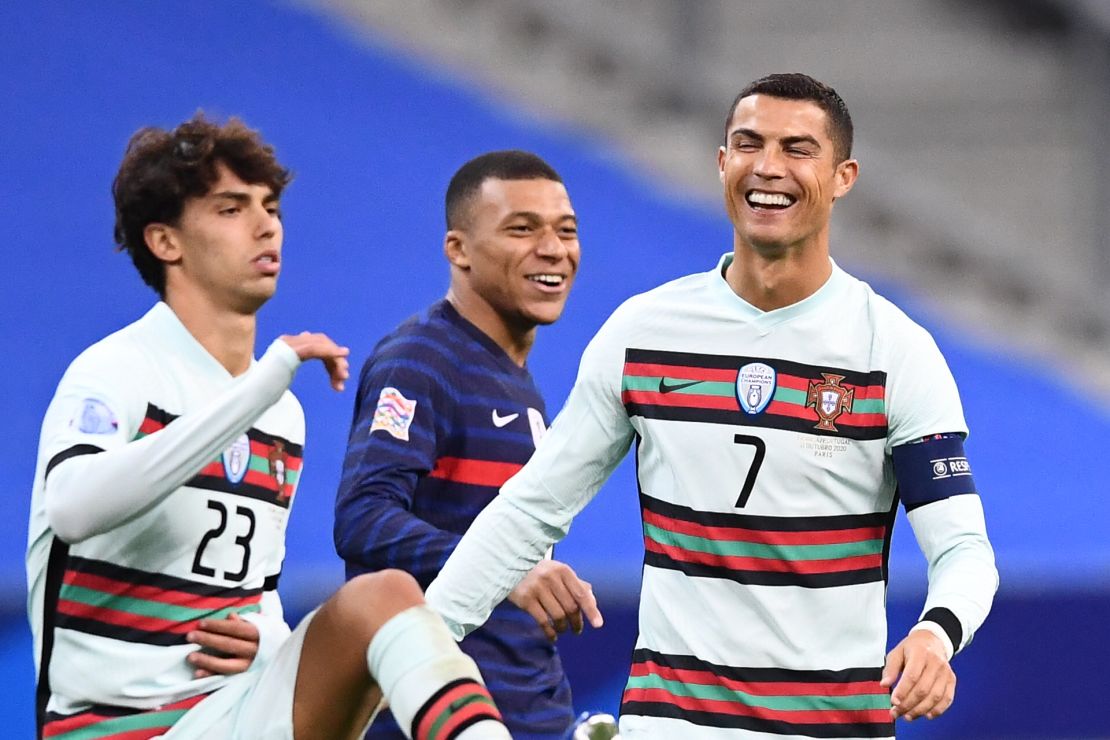 Ronaldo (right) shares a joke with French striker Kylian Mbappe (center) during Portugal's Nations League match. 