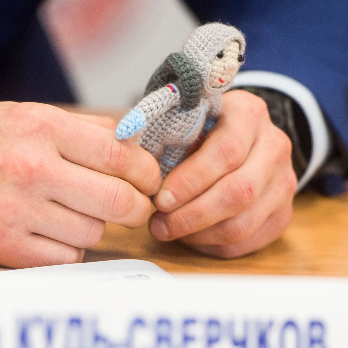 Sergey Kud-Sverchkov holds a knit cosmonaut named Yuri made by his wife Olga, during a press conference prior to his launch.