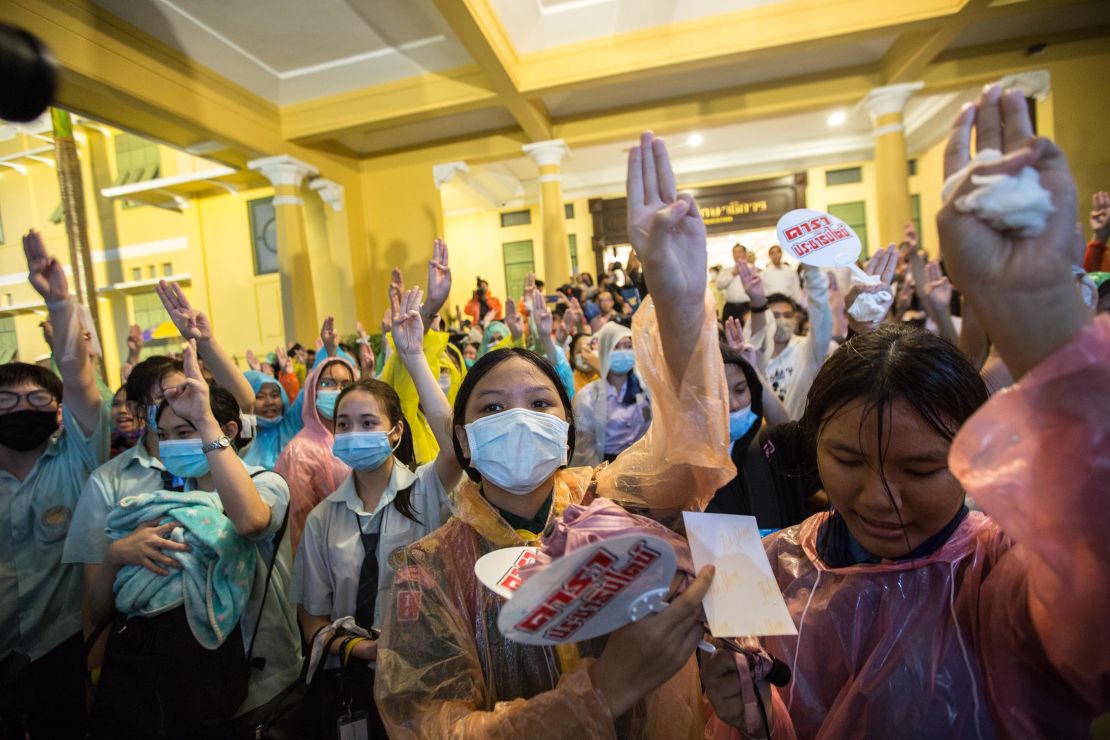 High school students raise their hands showing the three-finger sign during a protest in front of the Ministry of Education building in Bangkok on October 2.