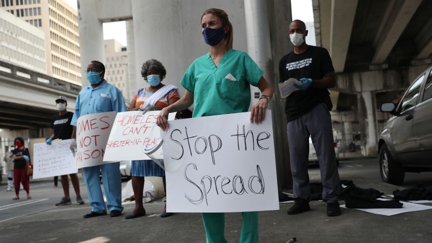 MIAMI, FLORIDA - APRIL 17: Volunteers, health care workers and doctors participate in a protest against what they say is the city's and county's poor response to helping the homeless during the coronavirus outbreak on April 17, 2020 in Miami, Florida.  Dr. Henderson and several group organizations are helping the homeless by providing tests, protective masks, gloves, tents, and other items to the people in need. The groups are calling on local officials to make hotels, dorm rooms and other properties immediately available to house people; cancel all rent and mortgages; halt all evictions and end the arrest of homeless people.  (Photo by Joe Raedle/Getty Images)