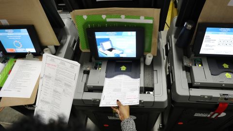 An election worker feeds ballots into voting machines during an accuracy test at the Miami-Dade Election Department headquarters on October 14, 2020, in Doral, Florida. 