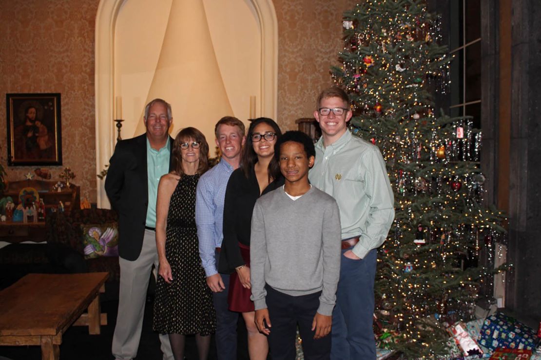 The Triplett family is pictured in an old Christmas photo, from left: Kirk with his wife Cathi, son Sam, adopted daughter Lexy, adopted son Kobe, and son Conor. 