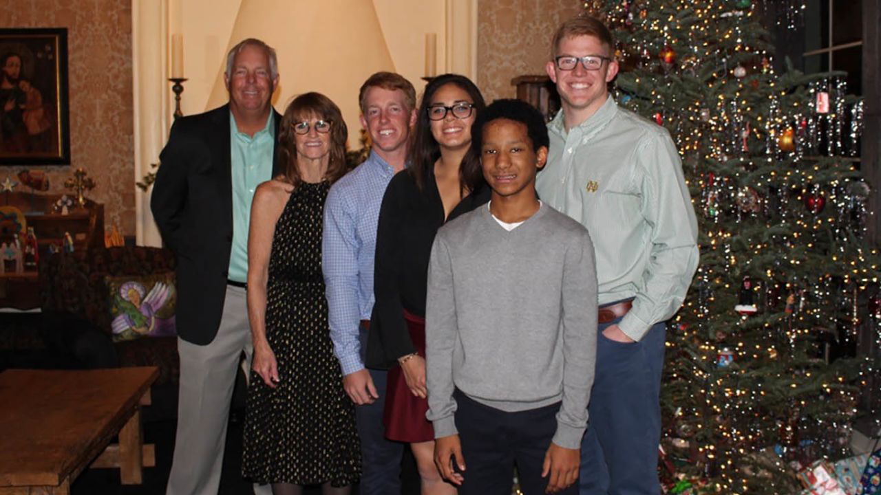 The Triplett family is pictured in an old Christmas photo, from left: Kirk with his wife Cathi, son Sam, adopted daughter Lexy, adopted son Kobe, and son Conor.