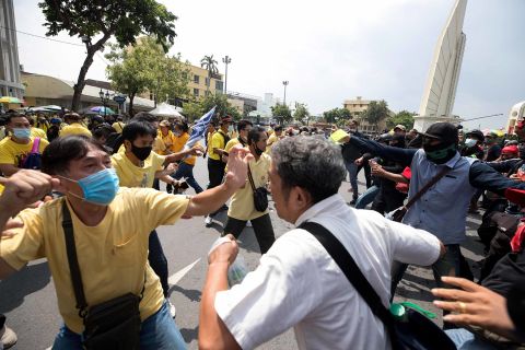 A pro-democracy protester, right, and and a supporter of the monarchy, in yellow, exchange blows at a rally near the Democracy Monument in Bangkok on October 14.