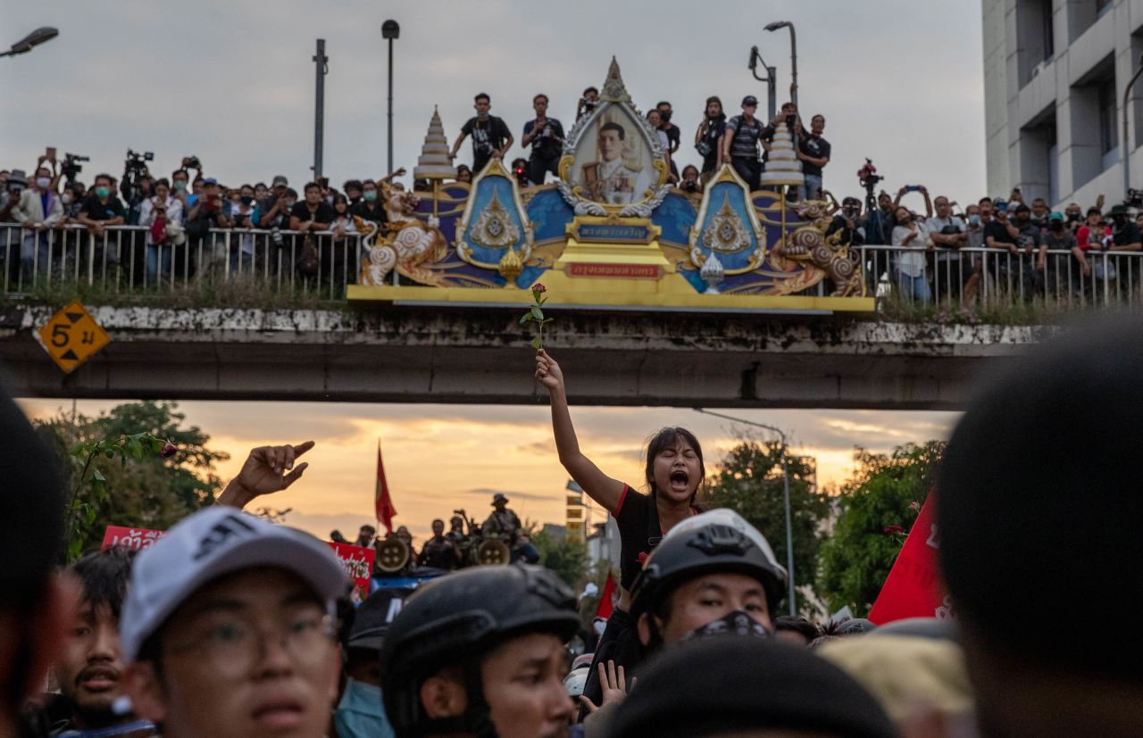 Pro-democracy protesters march past a portrait of Thai King Maha Vajiralongkorn on October 14.