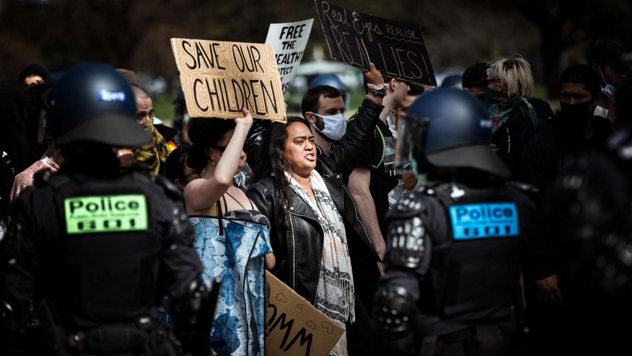Protestors hold QAnon-related signs during an anti-lockdown demonstration in Melbourne, Australia on September 5th. Some QAnon followers falsely believe the Covid-19 pandemic is an elaborate hoax. (Darrian Traynor/Getty Images AsiaPac)