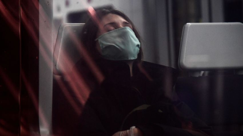 TOPSHOT - A woman wearing a face mask sleeps on a train at the Atocha Station in Madrid on April 13, 2020 as some companies were set to resume operations at the end of a two-weeks halt of all non-essential activity amid a national lockdown to stop the spread of the COVID-19 coronavirus. - The death toll from the coronavirus pandemic has slowed in some of the worst-hit countries, with Spain readying to reopen parts of its economy as governments grapple with a once-in-a-century recession. (Photo by JAVIER SORIANO / AFP) (Photo by JAVIER SORIANO/AFP via Getty Images)
