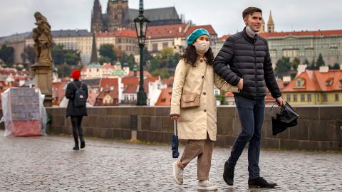 Tourists walk across Prague's medieval Charles Bridge as the Czech Republic faces a record spike after previously keeping numbers low.