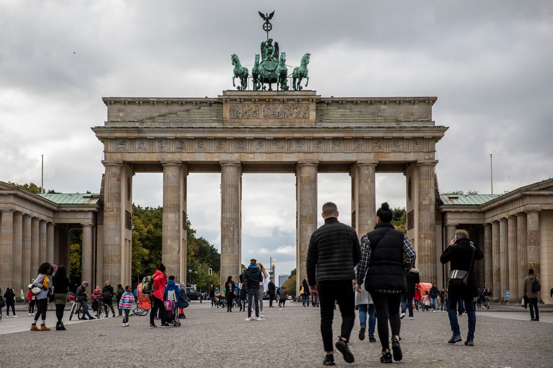 Tourists walk at the Brandenburg Gate in Berlin on Tuesday, as the city's businesses fight curfew orders in the courts.