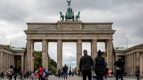 Tourists walk at the Brandenburg Gate in Berlin on Tuesday, as the city's businesses fight curfew orders in the courts.