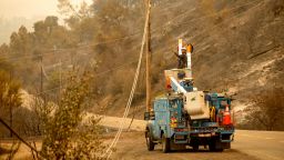 As the LNU Lightning Complex fires burn nearby, a PG&E worker clears a power line blocking a roadway in unincorporated Napa County, Calif., on Thursday, Aug. 20, 2020. Fire crews across the region scrambled to contain dozens of wildfires sparked by lightning strikes. (AP Photo/Noah Berger)