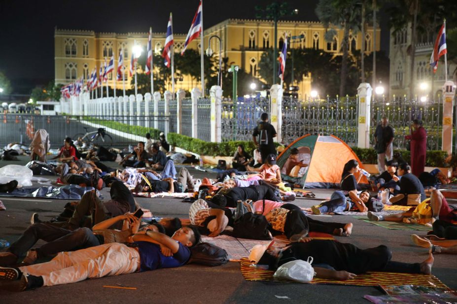 Protesters sleep in front of Government House in Bangkok during a demonstration on October 15.