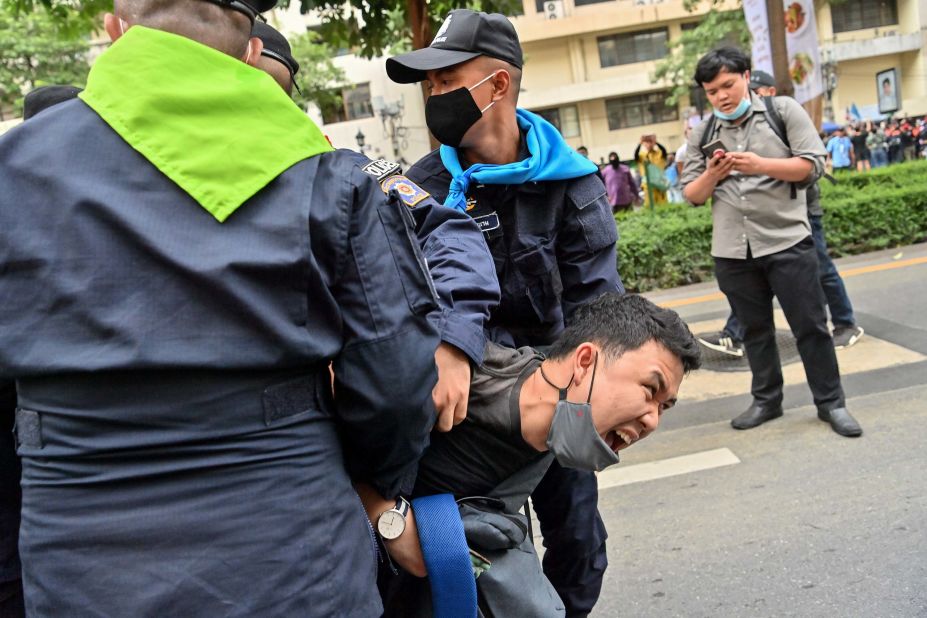 A pro-democracy protester reacts as police try to detain him during a rally in Bangkok on October 15.