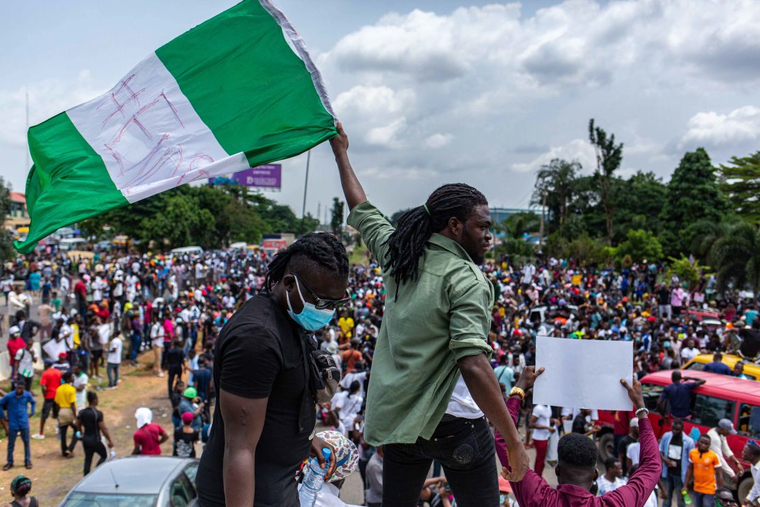 A Nigerian youth seen waving the Nigerian national flag during the protests. 