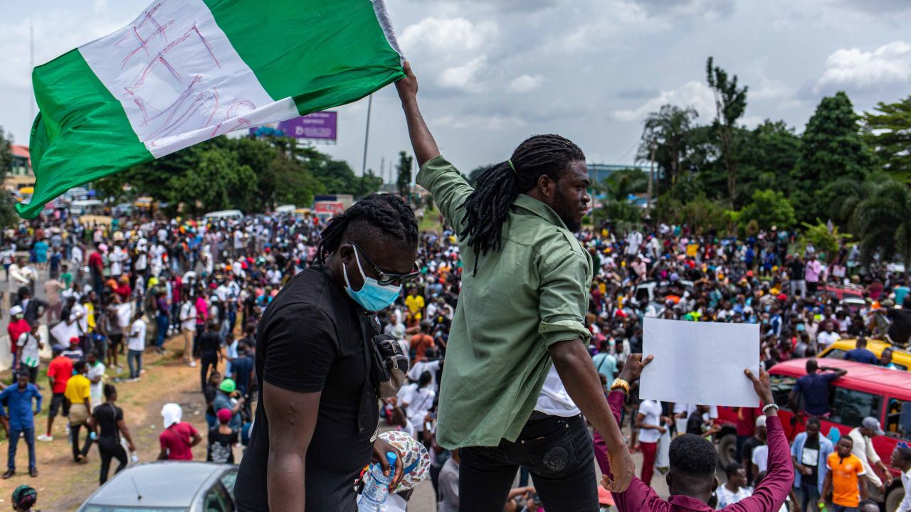 A Nigerian youth seen waving the Nigerian national flag during the protests. 