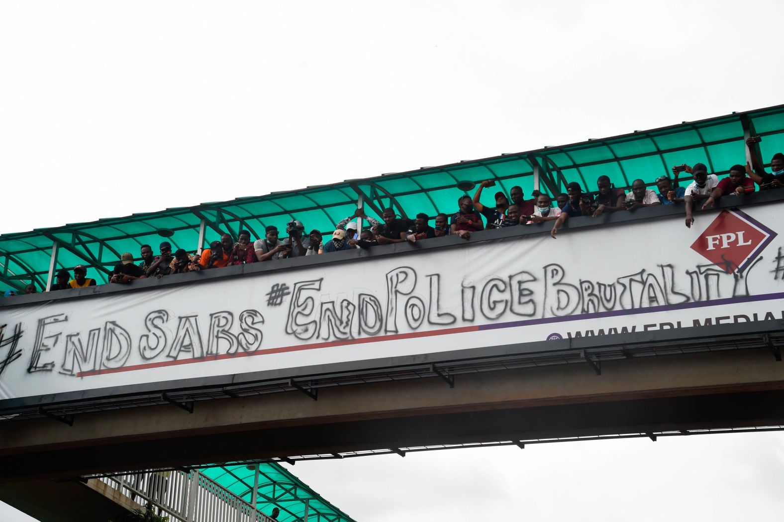 People protest from a pedestrian bridge in Lagos on Thursday, October 15.