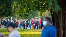 Voters line up outside of the Southpark Meadows Mega-Center on October 13, 2020. Polls opened at 7 a.m. and hundreds of voters came out early to cast their votes. Austin, Texas.