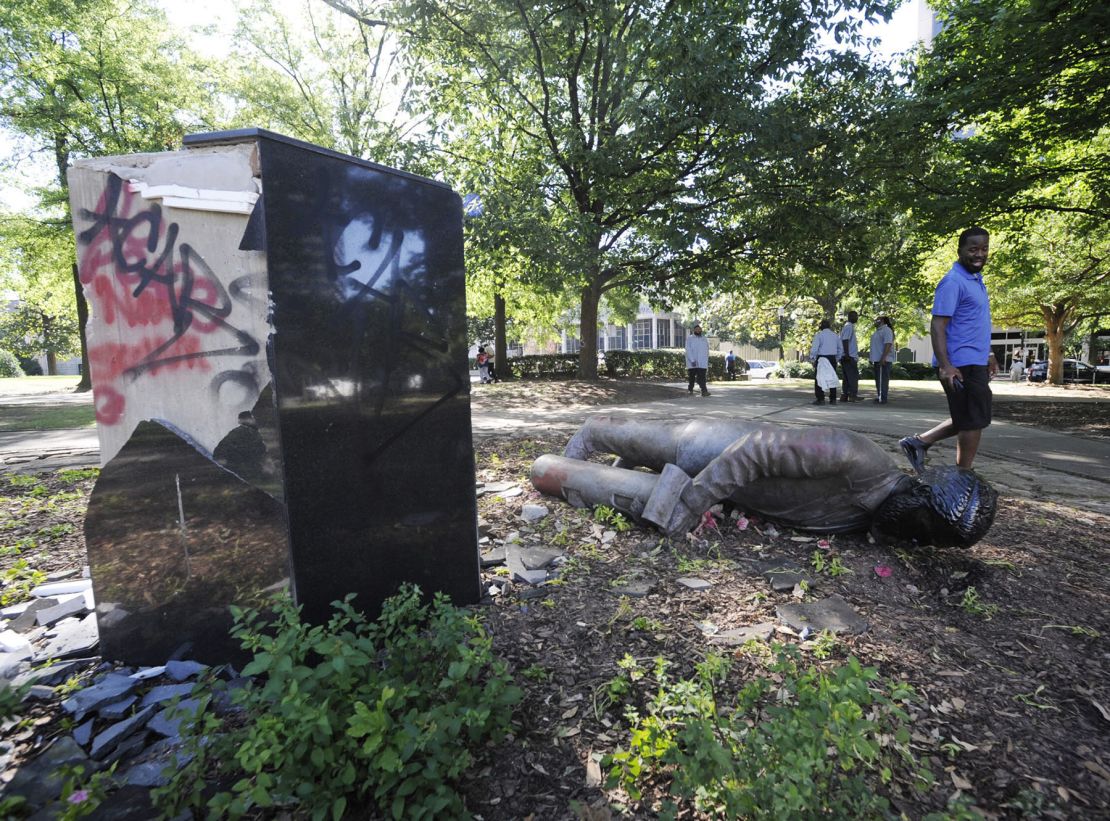A man walks past a toppled statue of Charles Linn, a city founder who was in the Confederate Navy, in Birmingham, Alabama on June 1, 2020.