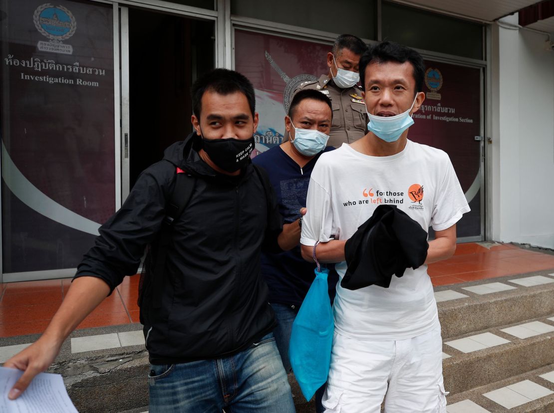 Thai pro-democracy activist Ekachai Hongkangwan (R) is escorted by police officers after being arrested, at Lat Phrao police station in Bangkok, on 16 October 2020. 