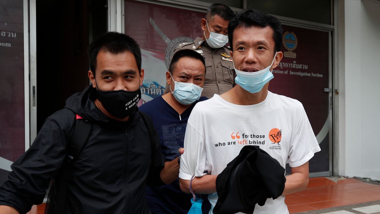 Thai pro-democracy activist Ekachai Hongkangwan (R) is escorted by police officers after being arrested, at Lat Phrao police station in Bangkok, on 16 October 2020. 
