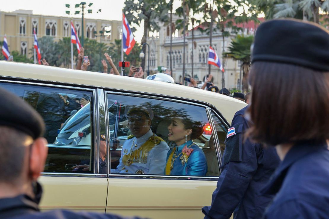 Thailand's Queen Suthida (C) and Prince Dipangkorn Rasmijoti (centre L) react inside a royal motorcade as it drives past a pro-democracy rally in Bangkok on October 14, 2020. 