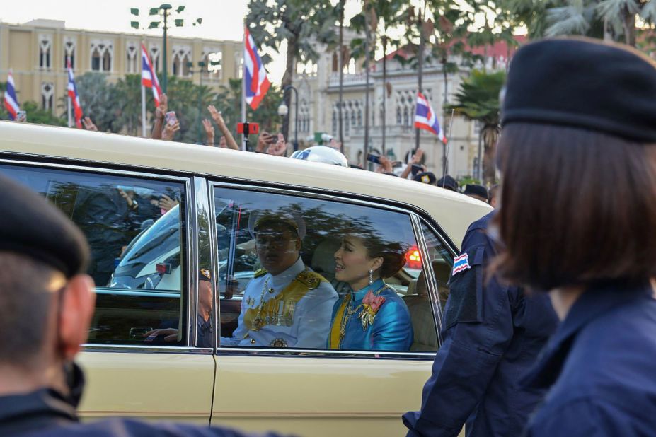 Thailand's Queen Suthida, center, and Prince Dipangkorn Rasmijoti, center-left, ride inside a royal motorcade as it drives past a pro-democracy rally on October 14.