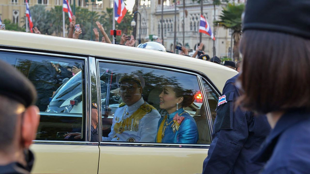 Thailand's Queen Suthida (C) and Prince Dipangkorn Rasmijoti (centre L) react inside a royal motorcade as it drives past a pro-democracy rally in Bangkok on October 14, 2020.