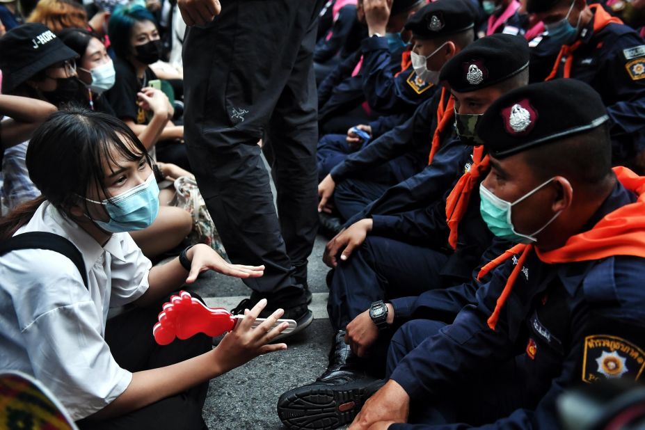 A young pro-democracy protester talks with police during a demonstration in Bangkok on October 15.