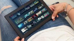 A woman watches Netflix on a tablet