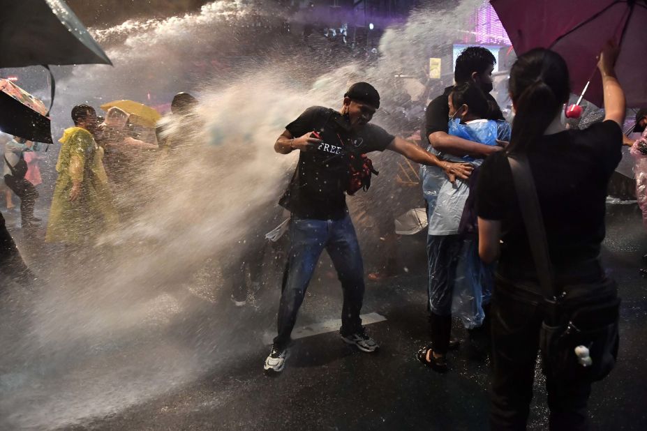 Pro-democracy protesters are blasted by police water cannons on October 16.